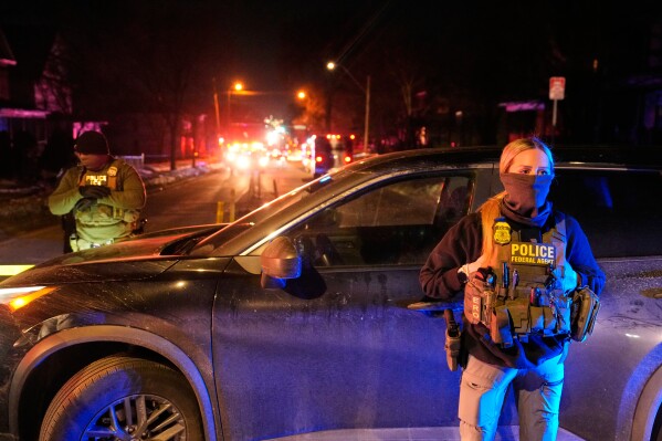 Federal immigration officers at the scene of a reported shooting Wednesday, Jan. 14, 2026, in Minneapolis. (AP Photo/John Locher)