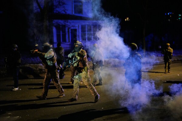 Federal immigration officers shoot pepper balls as tear gas is deployed at the scene of a reported shooting Wednesday, Jan. 14, 2026, in Minneapolis. (AP Photo/John Locher)