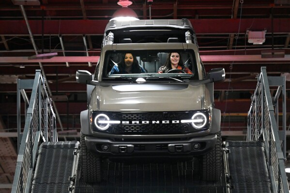 A guest is driven in a Ford Bronco on a test drive course by a Ford employee at the Detroit Auto Show, Wednesday, Jan. 14, 2026, in Detroit. (AP Photo/Jose Juarez)