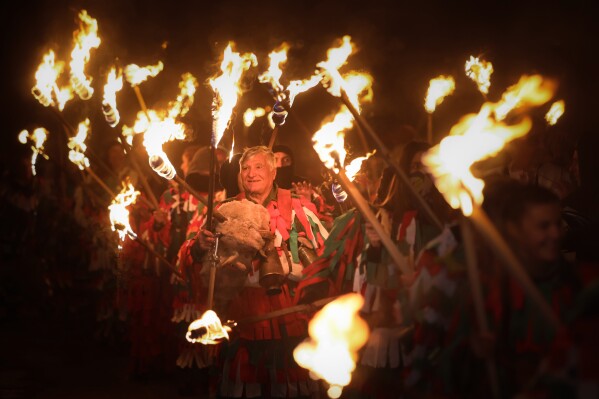 A man smiles during the ancient Surva pagan ritual in the village of Dolna Sekirna, Bulgaria, late Tuesday, Jan. 13, 2026, as masked dancers mark the New Year by driving away evil spirits and invoking health, fertility, and prosperity. (AP Photo/Valentina Petrova)