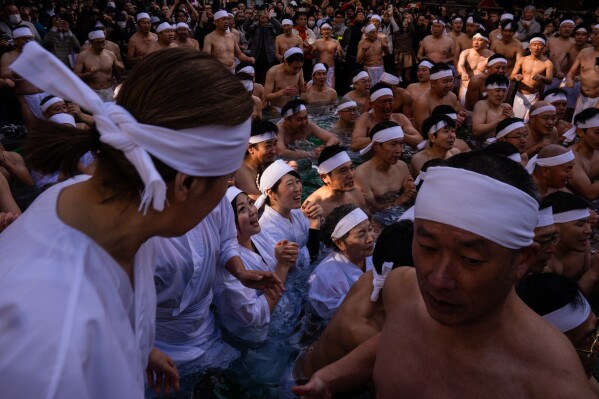 Participants bathe in ice-cold water to purify their souls and pray for good health during a New Year's ritual at Teppozu Inari Shrine in Tokyo, Sunday, Jan. 11, 2026. (AP Photo/Louise Delmotte)