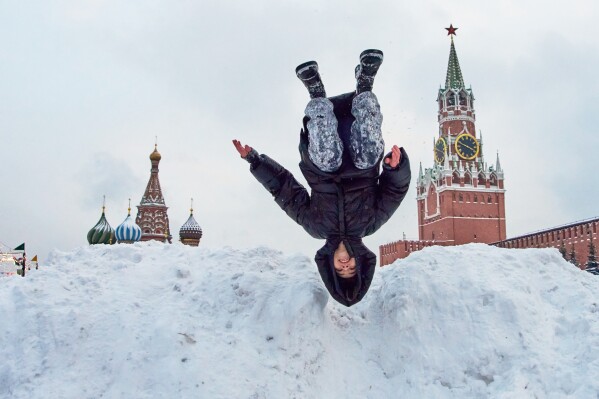 A girl shows off her skills atop of a pile of snow on Red Square after heavy snowfall in Moscow, on Saturday, Jan. 10, 2026, backdropped by the St. Basil's Cathedral. (AP Photo/Alexander Zemlianichenko)