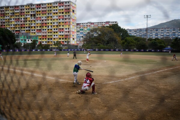 Children play baseball at the 23 de Enero neighborhood in Caracas, Venezuela, Saturday, Jan. 10, 2026, a week after U.S. forces captured Venezuelan President Nicolas Maduro. (AP Photo/Matias Delacroix)