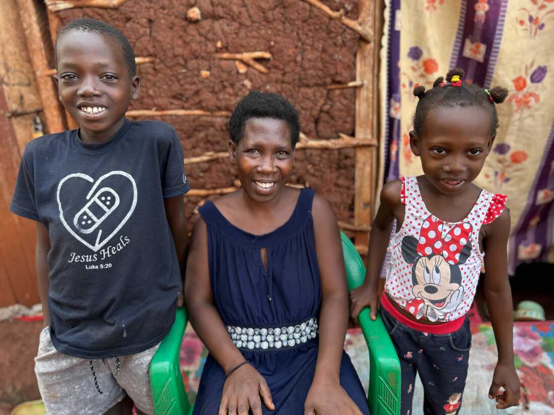 Deborah Nanyonga, who’s battling cervical cancer, with her children Prosper (left) and Jovia outside their home near the Jinja-Tororo highway.
