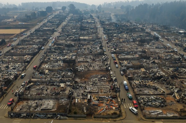 Residential areas burned by wildfires stretch across Tome, Chile, Monday, Jan. 19, 2026. (AP Photo/Javier Torres)