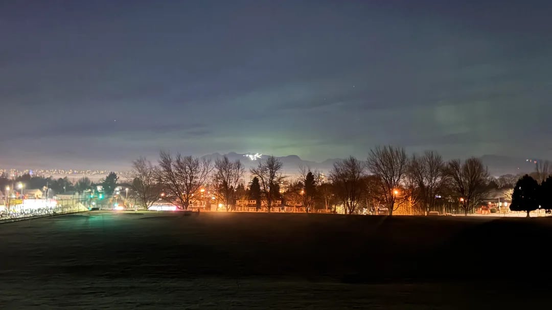 Faint green lights above a cityscape.