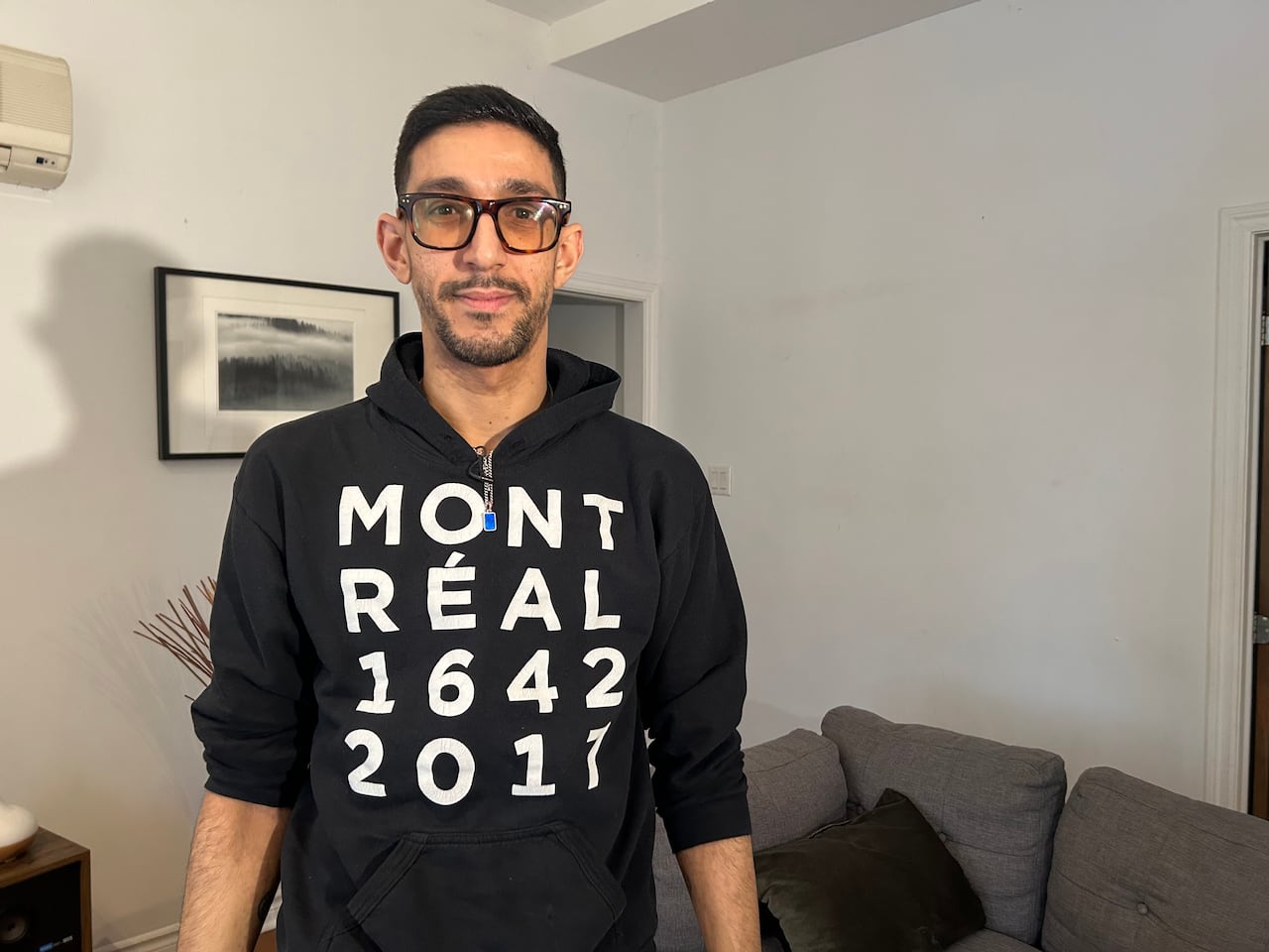 A man standing up in a black shirt for a photo.