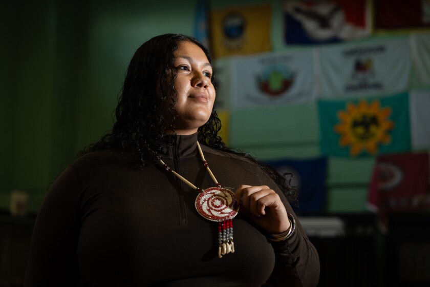 Dnisa Oocumma, of the Eastern Band of Cherokee Indians, who is the community engagement coordinator at the American Indian Center, stands at the American Indian Center’s gym in Albany Park.