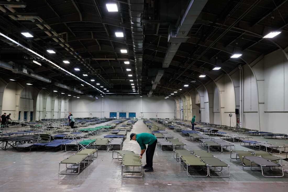Volunteers prepare cots at an inclement weather shelter ahead of a winter storm at Fair Parks Automobile Building in Dallas, Texas on Jan. 23, 2026. 