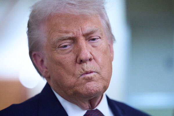 President Donald Trump speaks with reporters aboard Air Force One after leaving the World Economic Forum in Davos for Washington, Thursday, Jan. 22, 2026. (AP Photo/Evan Vucci)