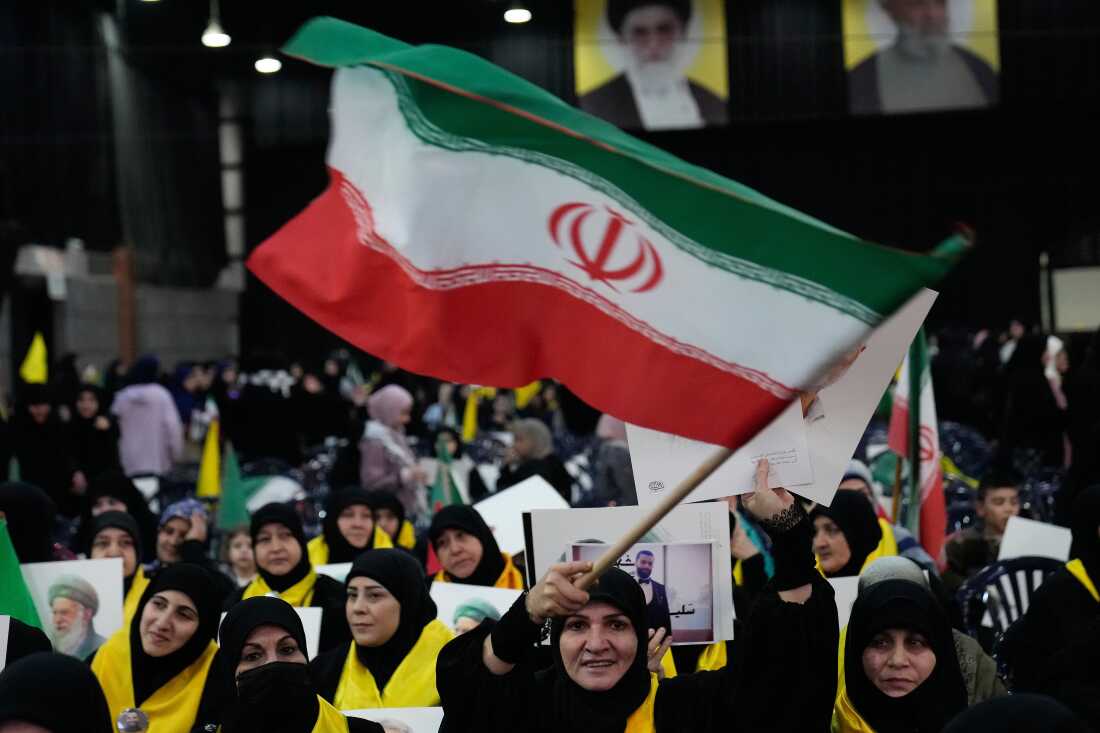 A Hezbollah supporter waves an Iranian flag during a rally to show their solidarity with the Iranian government, in the southern suburb of Beirut, Lebanon, Monday, Jan. 26, 2026.