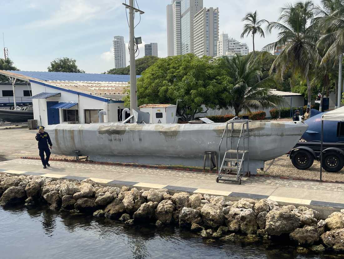 A Colombian naval officer walks past a confiscated drug sub.