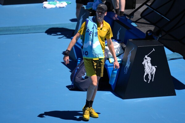 Jannik Sinner of Italy walks from the court as play is halted due to extreme heat during his third round match against Eliot Spizzirri of the U.S. at the Australian Open tennis championship in Melbourne, Australia, Saturday, Jan. 24, 2026. (AP Photo/Dita Alangkara)