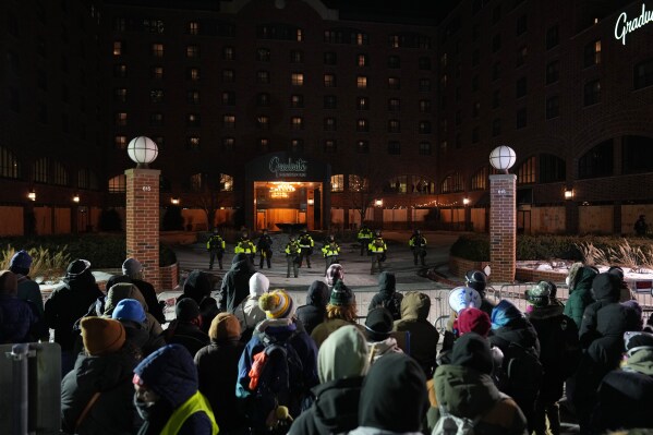 People participate during a noise demonstration outside the Graduate by Hilton Minneapolis hotel on Wednesday, Jan. 28, 2026, in Minneapolis. (AP Photo/Adam Gray)