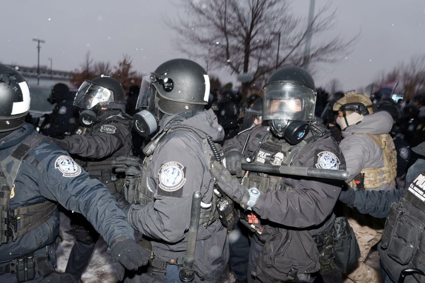 US Customs and Border Protection agents push demonstrators out of the street during a protest outside the Bishop Henry Whipple Federal Building, more than a week after a US Immigration and Customs Enforcement (ICE) agent fatally shot Renee Nicole Good on January 7.