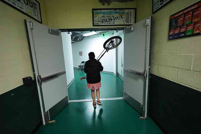 Red Panda carries her unicycle back to her dressing room after performing at halftime of an NCAA college basketball game between Miami and Stanford in Coral Gables, Fla., Wednesday, Jan. 28, 2026. (AP Photo/Rebecca Blackwell)