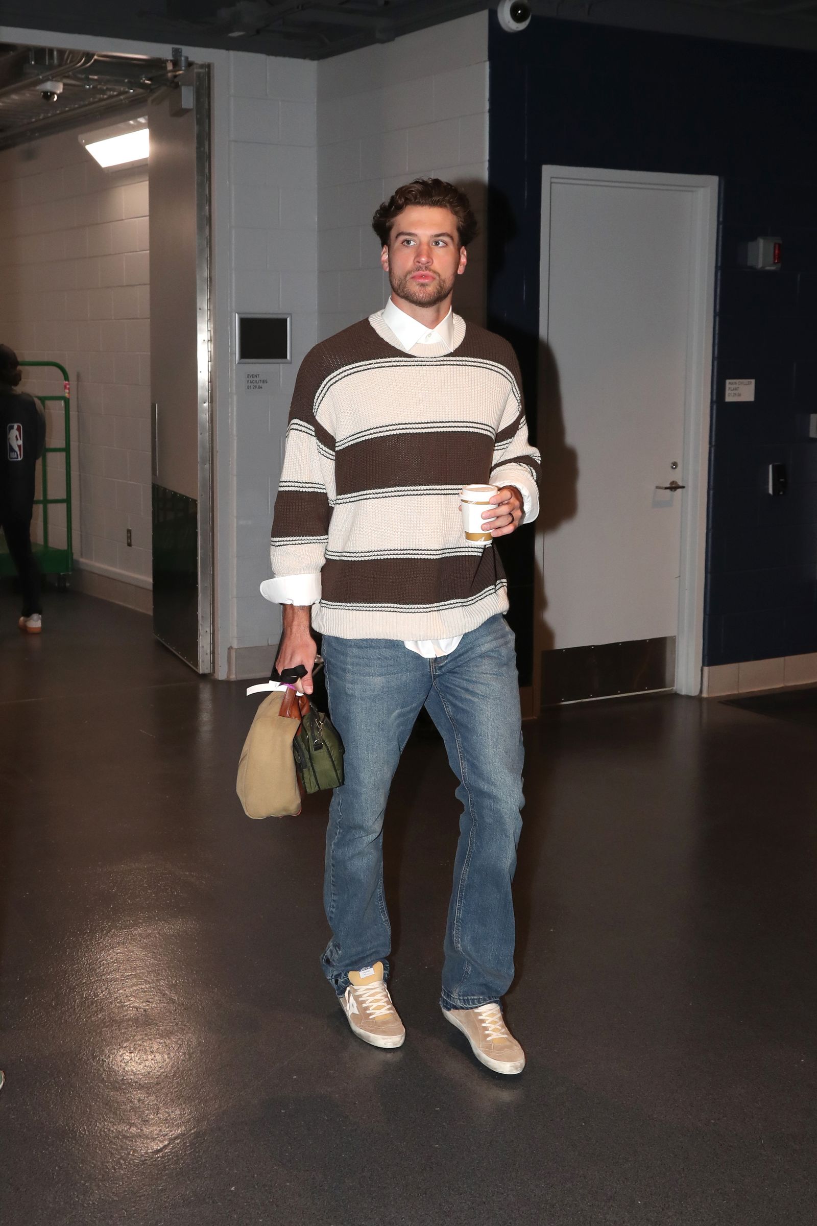 Image may contain Clothing Pants Jeans Person Standing Knitwear Sweater Adult Footwear and Shoe