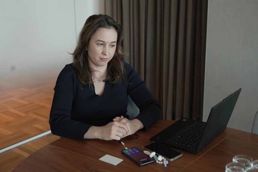 A woman looking at a laptop screen.