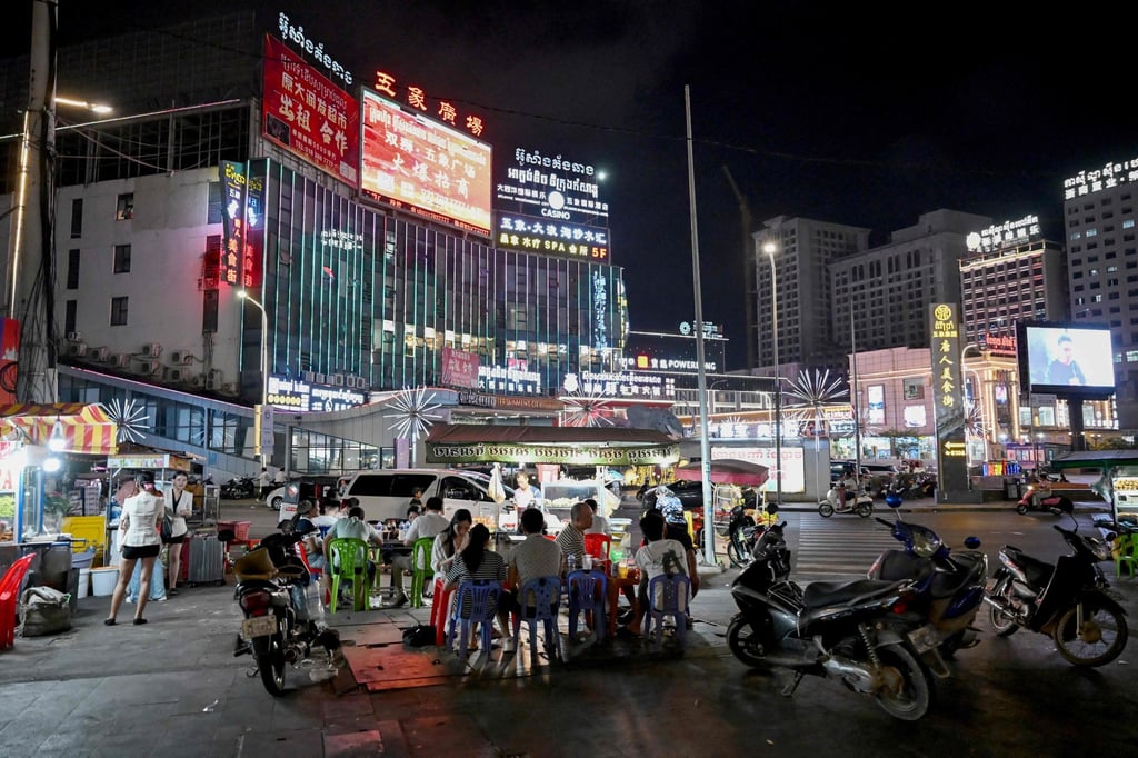 People eat next to street food stalls in Sihanoukville on Thursday. Cambodia is among four Southeast Asian nations on the recent US visa suspension list. Photo: AFP