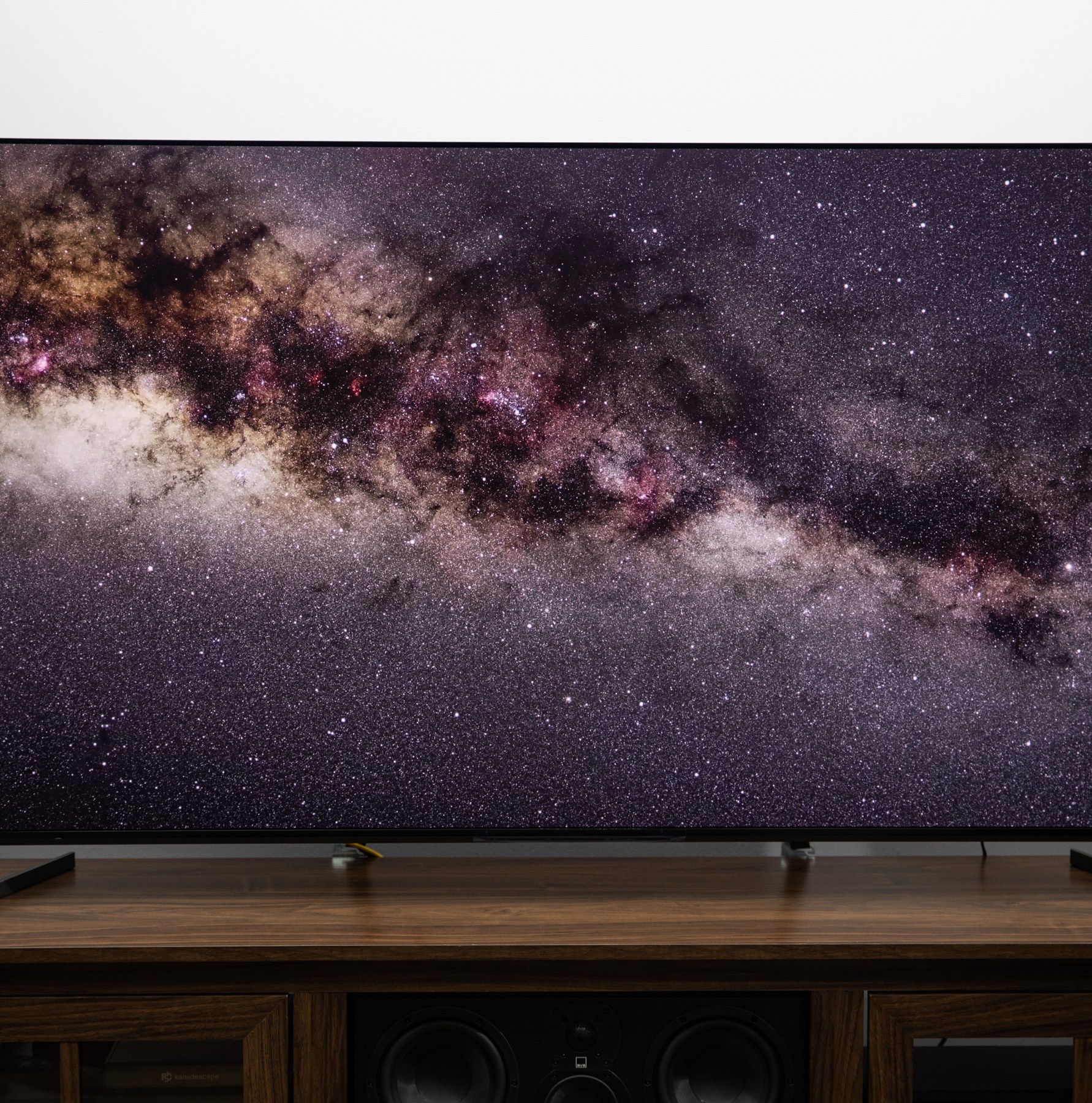 The Sony Bravia 8 II on a wooden TV stand displaying a starfield.
