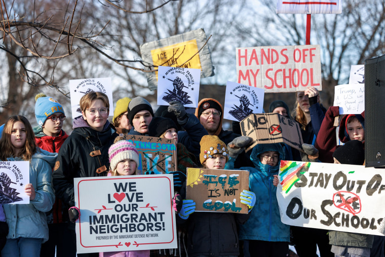 Minneapolis public school families, educators and students hold signs during a news conference at Lake Hiawatha Park in Minneapolis, on Friday, Jan. 9, 2026, demanding Immigration and Customs Enforcement be kept out of schools.