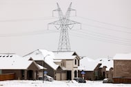A file photo shows large electrical transmission lines in a housing development in South...