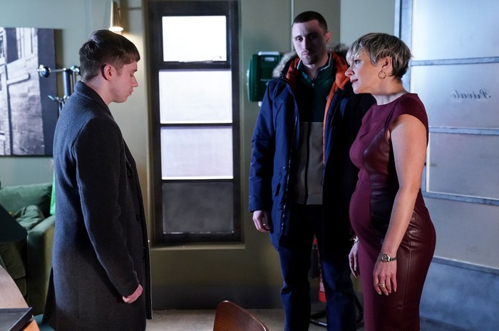 Barney stands opposite Nicola and Harry in a room in the club in a scene from EastEnders