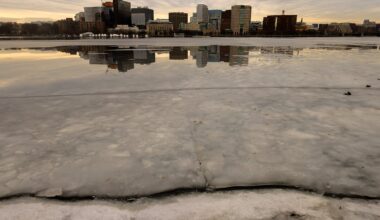 Buildings in Kendall Square in Cambridge are reflected on Charles River ice and water as seen from the Esplanade on January 14, 2026.