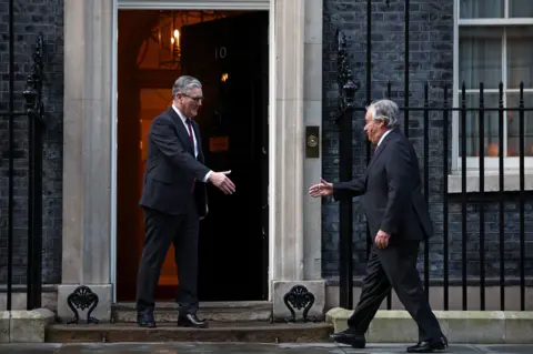Reuters António Guterres reaching out to shake Sir Keir Starmer's hand at Downing Street in a picture taken on 16 January