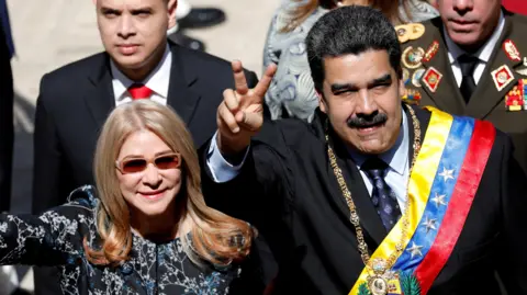 Reuters Venezuela's President Nicolás Maduro gestures next to his wife Cilia Flores during his arrival for a special session of the National Constituent Assembly 