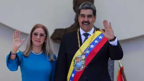 Getty Images Flores and Maduro waving to a crowd