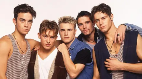 Getty Images Take That pose in vests and denim shirts for an early publicity photo
