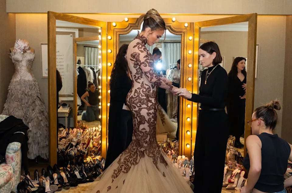 fitting session for a formal gown with several people involved