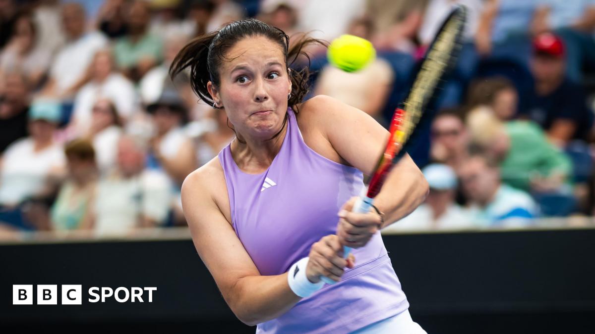 Daria Kasatkina, in a lilac tennis vest, plays a two-handed backhand shot as her eyes suggest intense focus