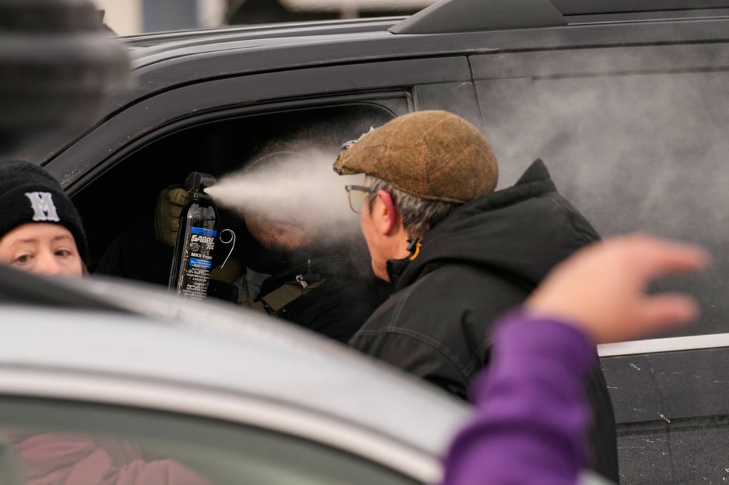 A federal immigration officer uses pepper spray on a person in Minneapolis. Photo: AP