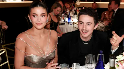 Getty Images Kylie Jenner and Timothee Chalamet sitting together at dinner table