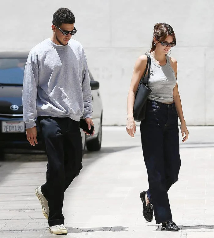 Devin Booker and Kendall Jenner walking side by side on the street, both wearing casual clothing and sunglasses