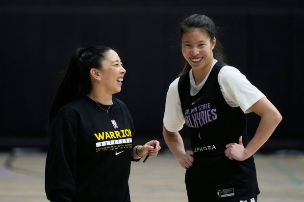 Golden State Valkyries head coach Natalie Nakase, left, laughs while talking with guard and former Flintridge Prep star Kaitlyn Chen during training camp May 2, 2025, at the WNBA team's facility in Oakland. (AP Photo/Jeff Chiu)