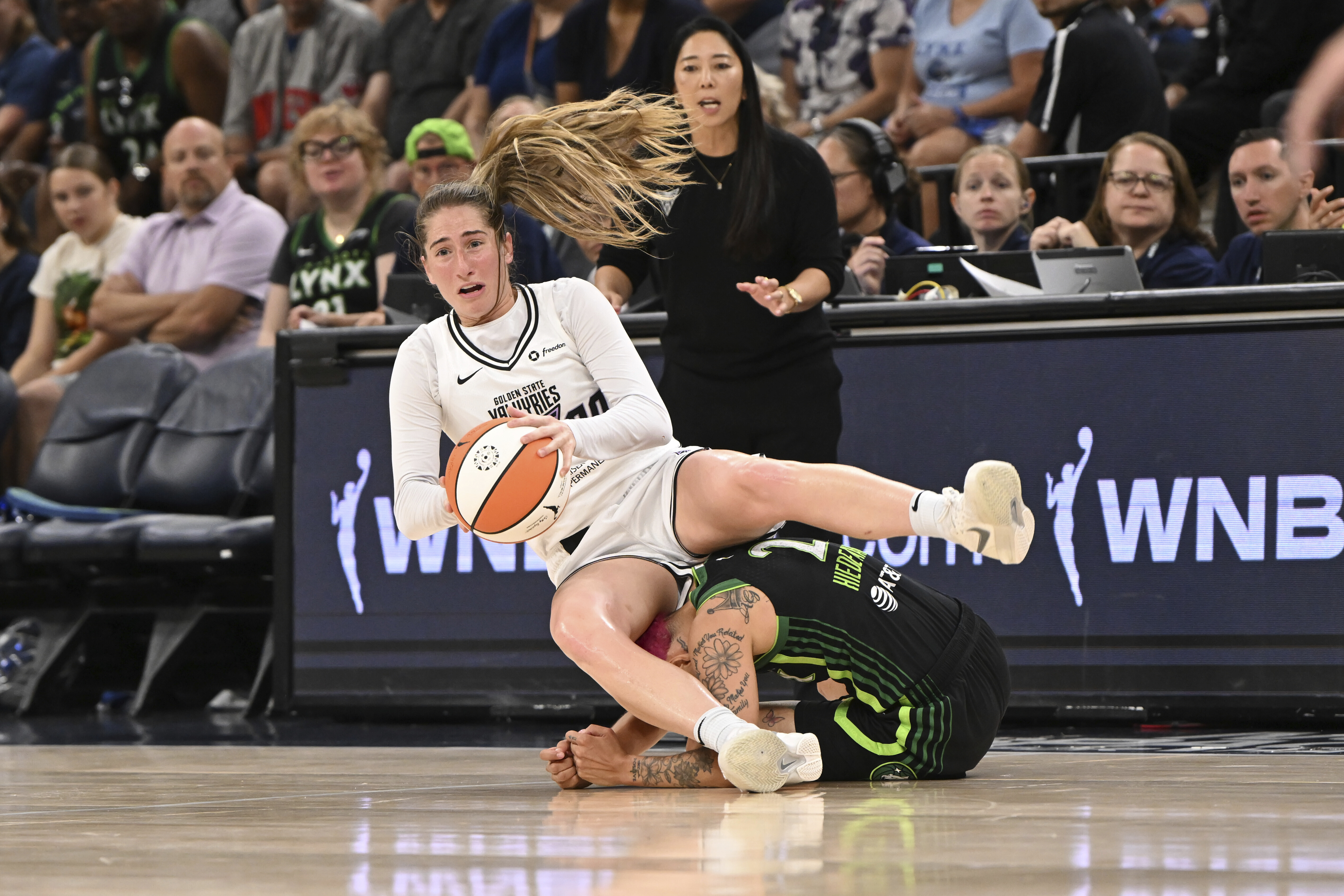Golden State Valkyries guard Kate Martin, left, falls over Minnesota...
