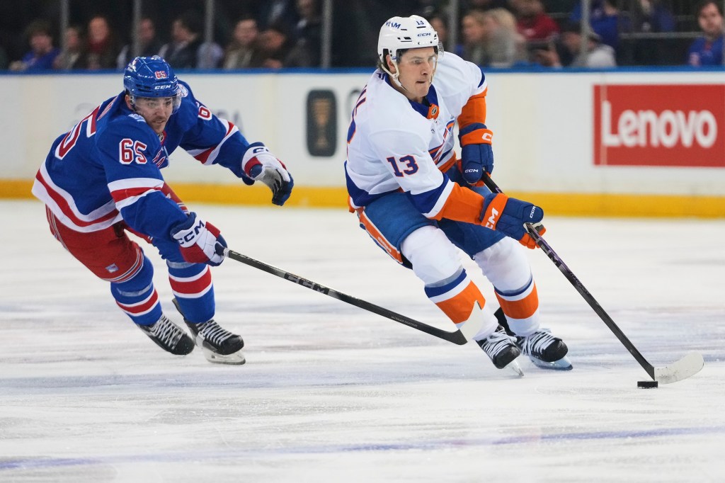 New York Islanders' Mathew Barzal (13) deke past New York Rangers' Brett Berard (65) during the first period of an NHL hockey game Thursday, Jan. 29, 2026, in New York. 