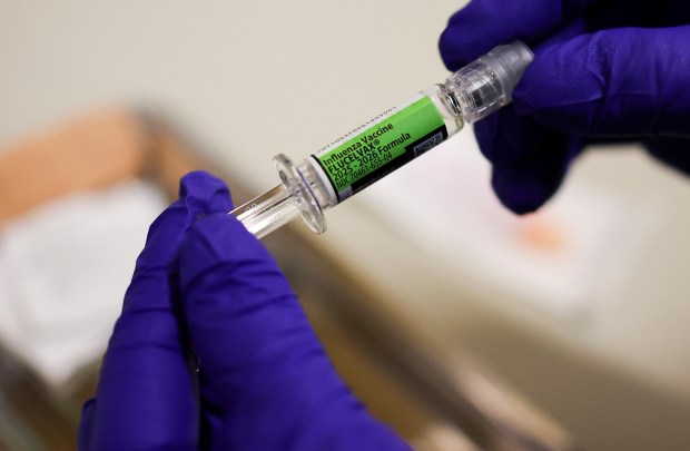 Medical assistant Loreal Velastegui holds a flu vaccine to be administered at the Esperanza Health Centers' Brighton Park North Clinic, Dec. 31, 2025. (Eileen T. Meslar/Chicago Tribune)
