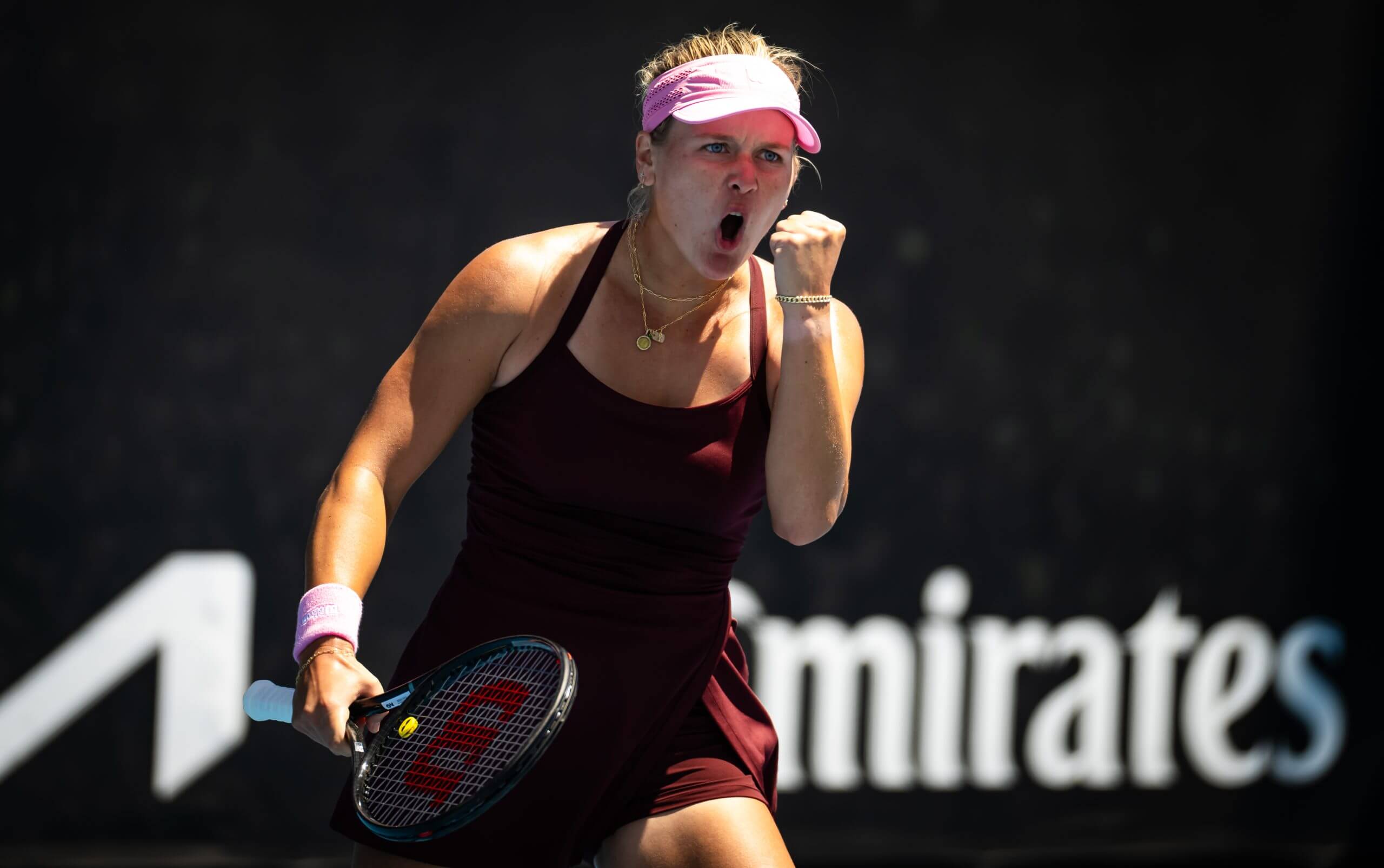 Peyton Stearns pumps her left fist in celebration while holding her tennis racket in her right hand.