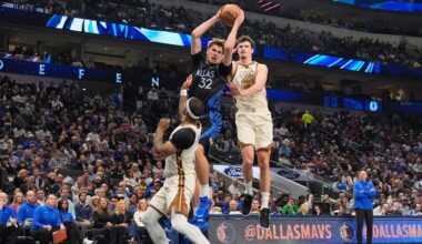 Dallas Mavericks forward Cooper Flagg (32) comes down with a rebound against Golden State Warriors' Gary Payton II, left, and Quinten Post, right, in the first half of an NBA basketball game in Dallas, Thursday, Jan. 22, 2026. (AP Photo/Tony Gutierrez)