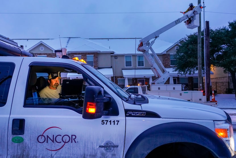 An Oncor crew works along Elsie Faye Heggins Street as power outages continue across the...