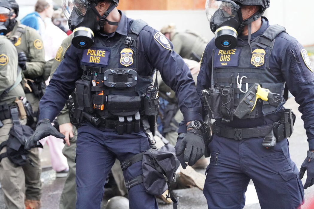 Department of Homeland Security police, along with other federal police, push and tackle protesters at the Immigration and Customs Enforcement facility south of downtown Portland on Sunday, Oct. 12, 2025