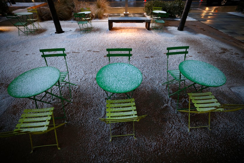 Tables are covered by snow at Klyde Warren Park, early Saturday morning, Jan. 24, 2026, in...