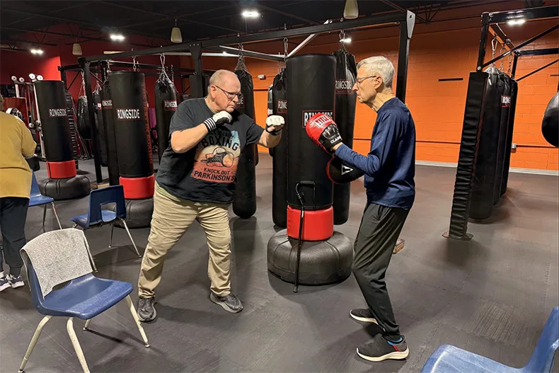 Dave Connors (left) practices boxing with a partner at the Parkinson's Exercise and Wellness Center. Connors said his Parkinson's disease symptoms have dramatically improved since attending classes at the center.