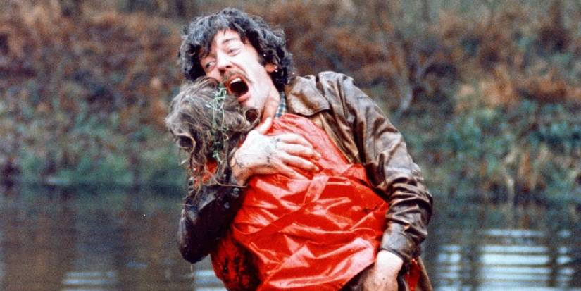 Donald Sutherland as John Baxter holding a child in a red coat while screaming in Don't Look Now