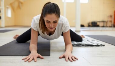 Woman performing frog pose during yoga class on yoga mat