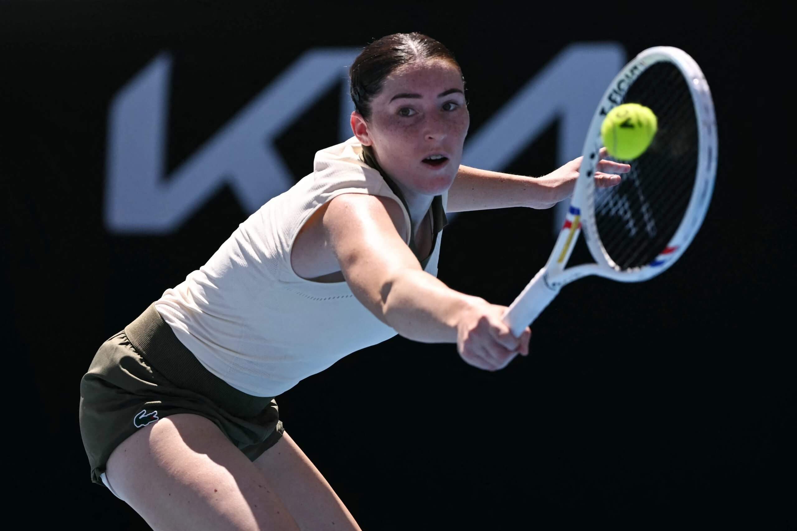 Elsa Jacquemot stretches to her left to hit a slice backhand.
